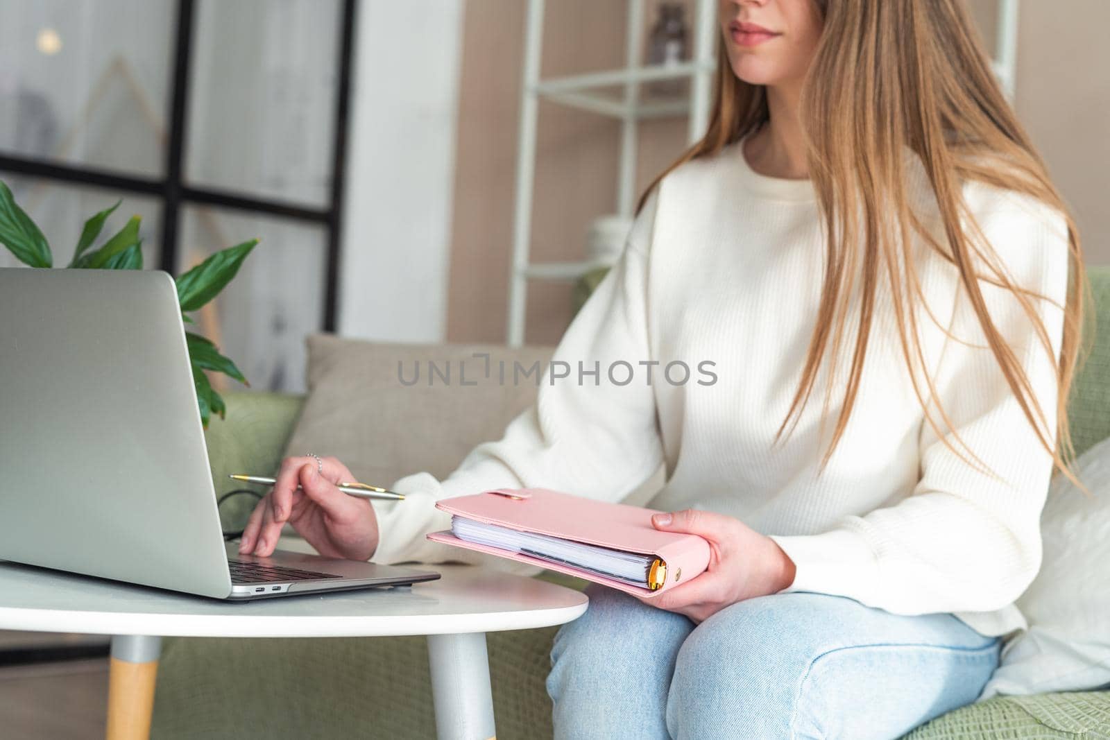 Distance learning online education and work. Business woman with notebook. Cropped freelance girl with laptop at home office. Using computer and online shops. Focus on hand