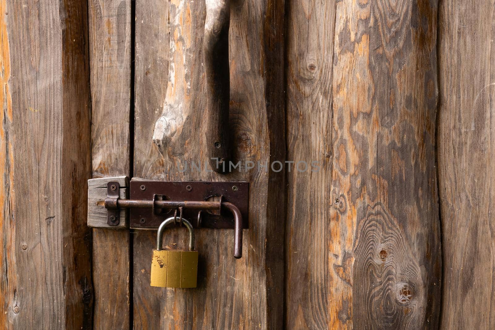 Old padlock on a wooden door by Andelov13