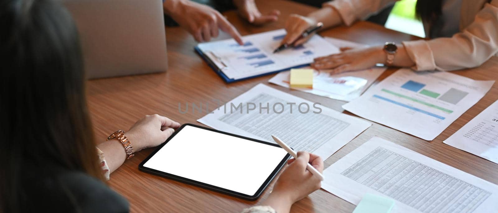 Business people brainstorming and discussing financial statistics together in boardroom.