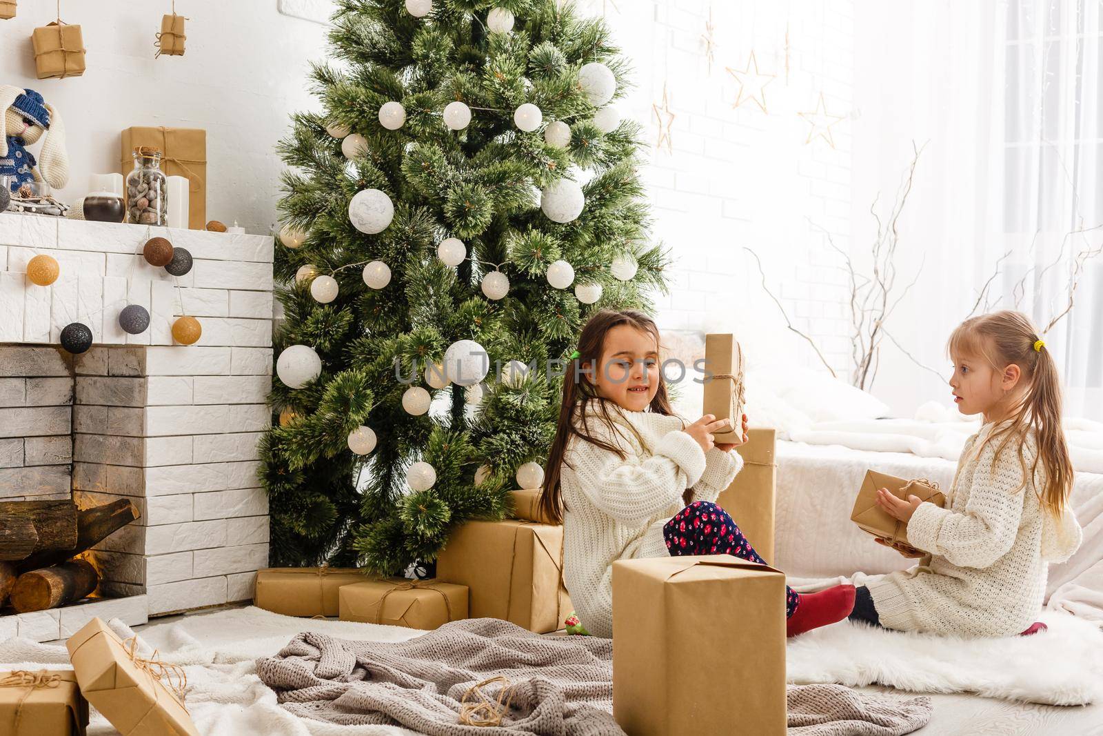 Kids little sisters hold gifts boxes interior background. What a great surprise. Small cute girls received holiday gifts. Best toys and christmas gifts. Children friends excited unpacking their gifts.