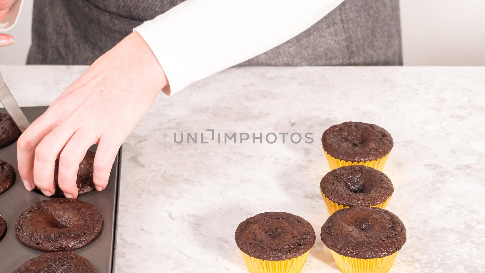 Step by step. Cooling freshly baked chocolate cupcakes to be decorated with buttercream frosting.