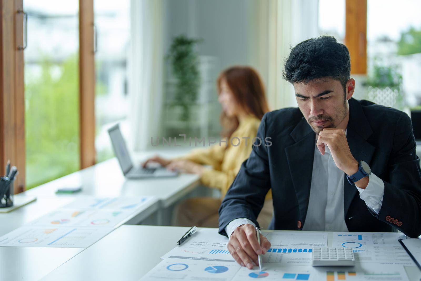 Portrait of a male businessman showing anxiety about making big investments to manage risks in the event of a marketing plan failure, taking financial and investment budget documents to working.