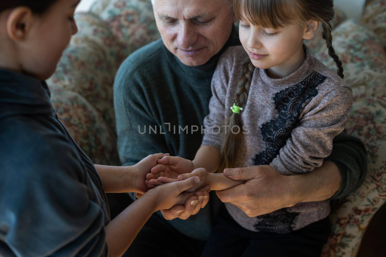 hands of grandfather and granddaughter with prayer.