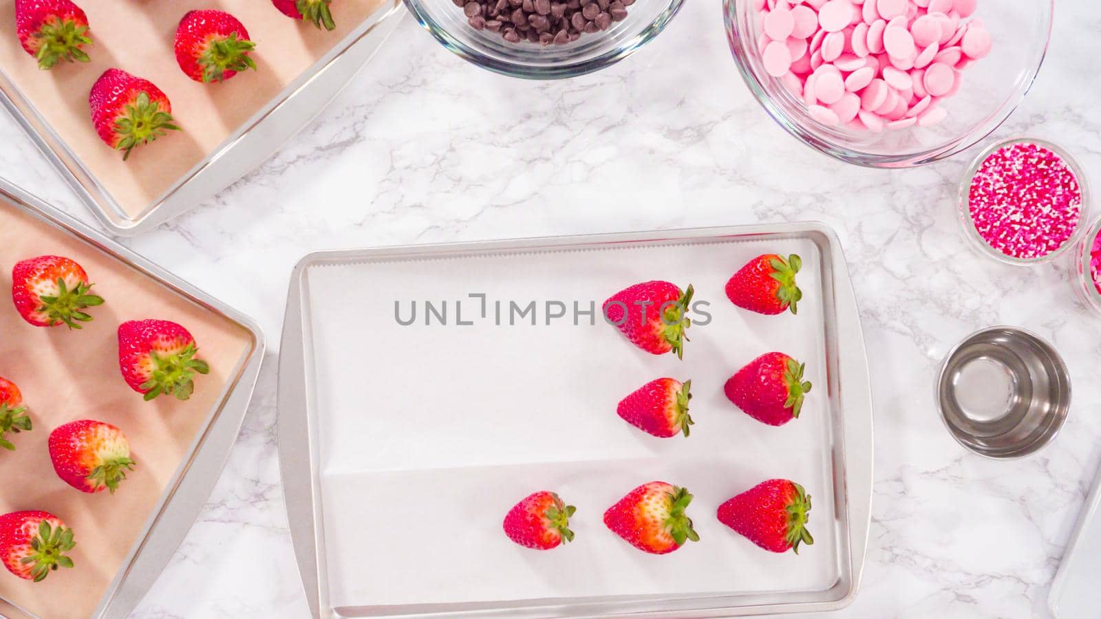 Flat lay. Step by step. Arranging organic strawberries on a baking sheet to make chocolate dipped strawberries.
