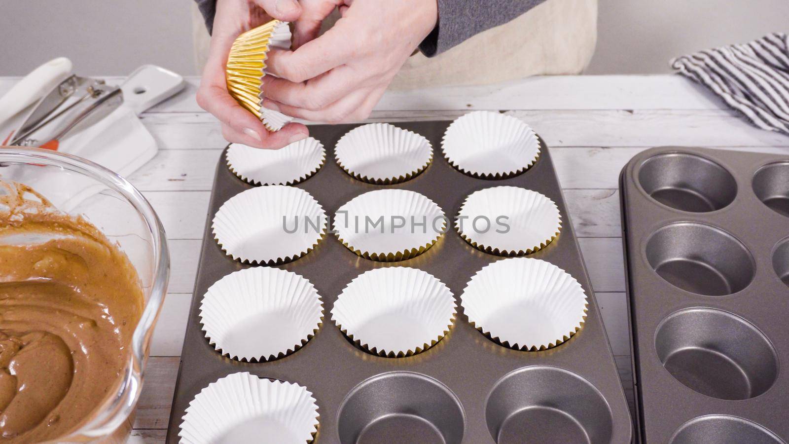 Cupcake pan lined with foil cupcake cups to bake chocolate raspberry cupcakes.