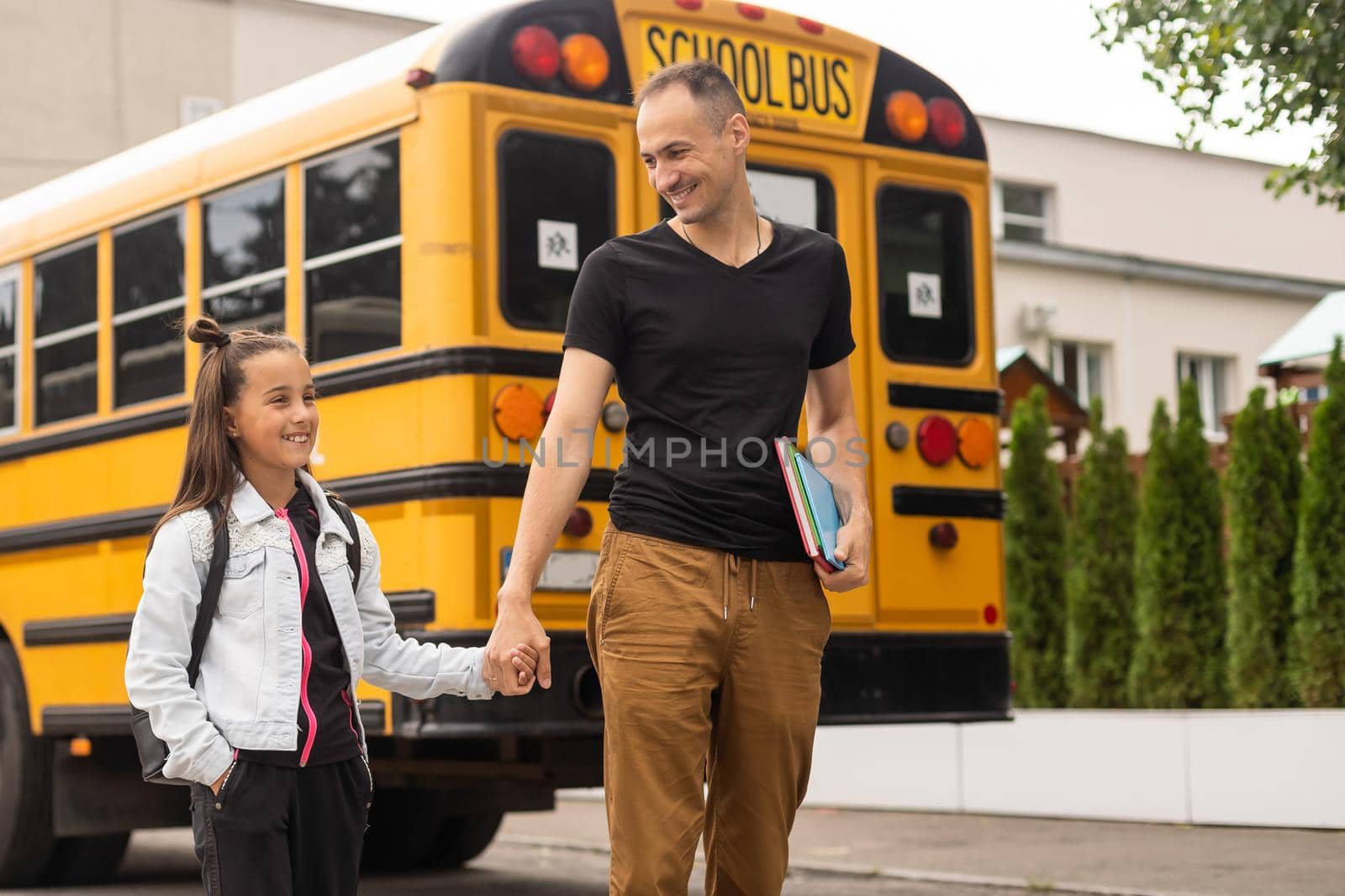 Cute little girl going to school with her father.