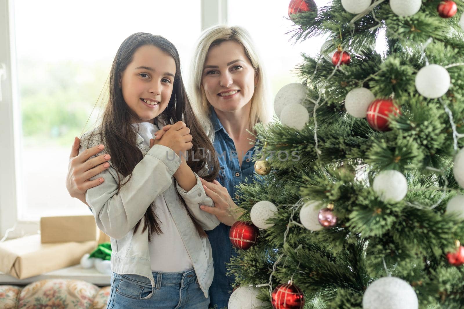 Mother with adult daughter, christmas tree.