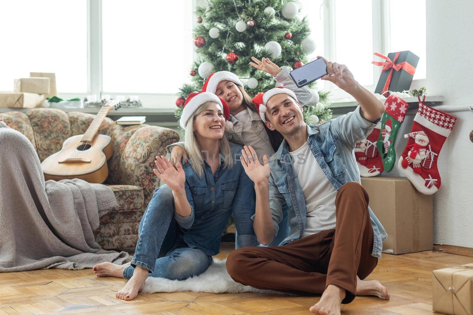 happy family mother, father and child daughter near Christmas tree at home by Andelov13