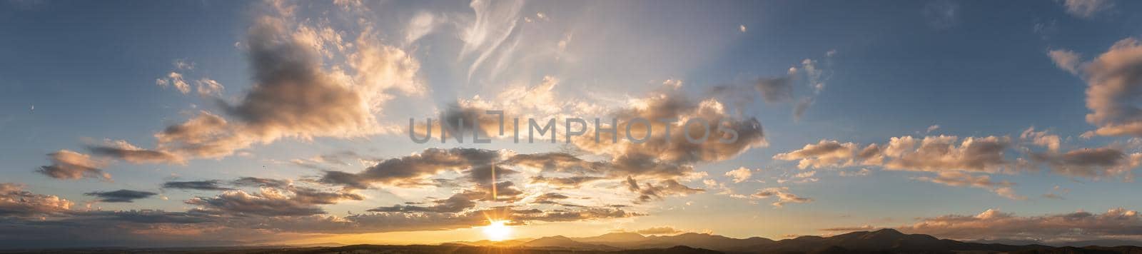 Dramatic clouds and sun in the sky at sunset by EdVal
