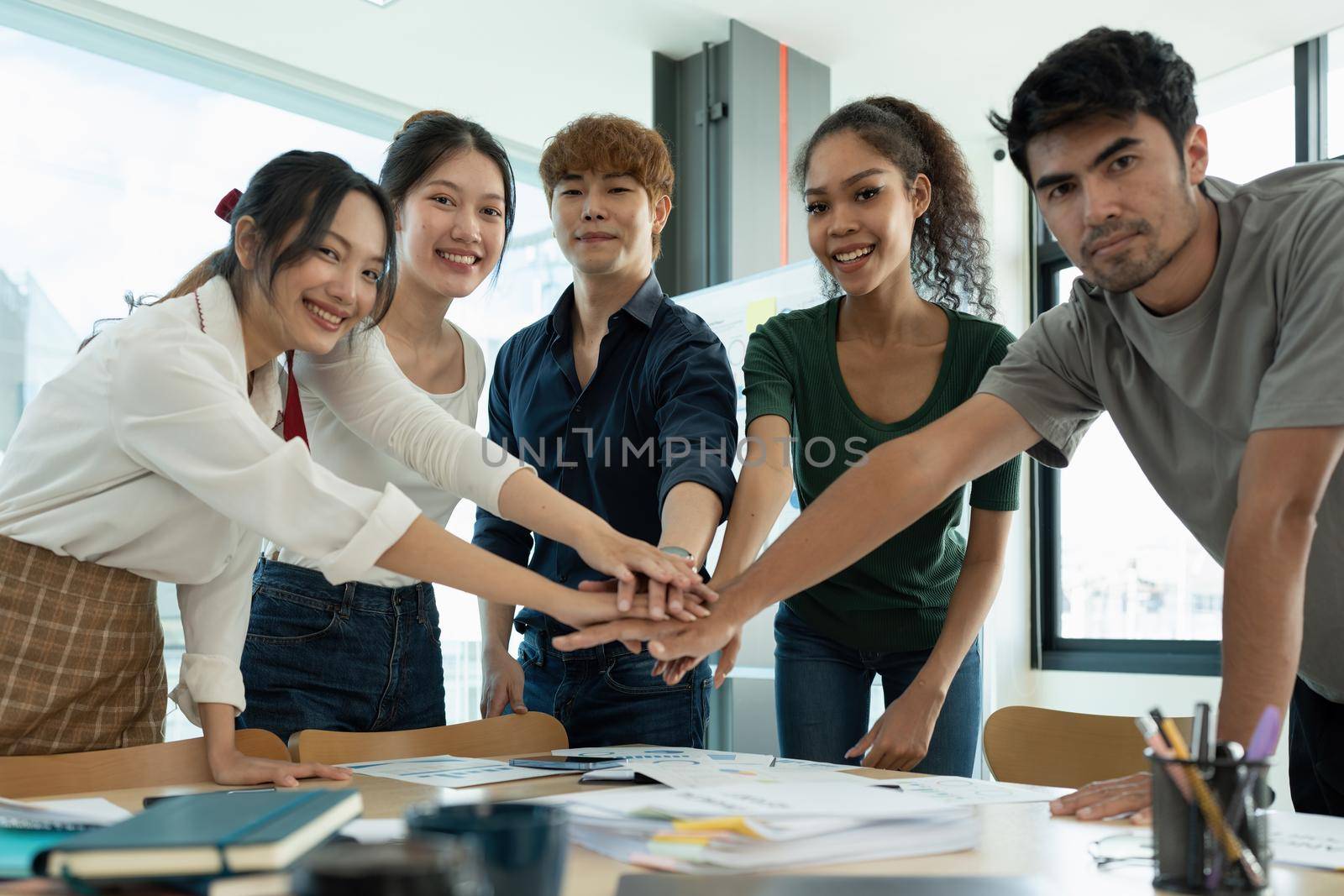 Group of business people putting their hands working together on wooden background in office. group support teamwork agreement concept.