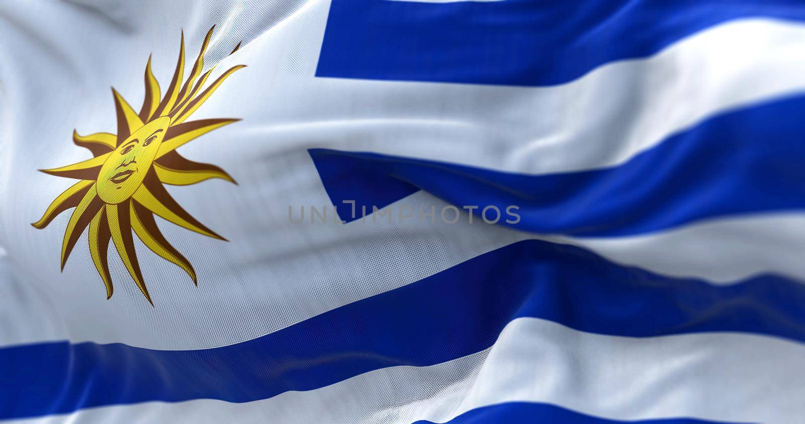 Close-up view of Uruguay national flag waving in the wind. The Oriental Republic of Uruguay is a country in South America. Fabric textured background. Selective focus