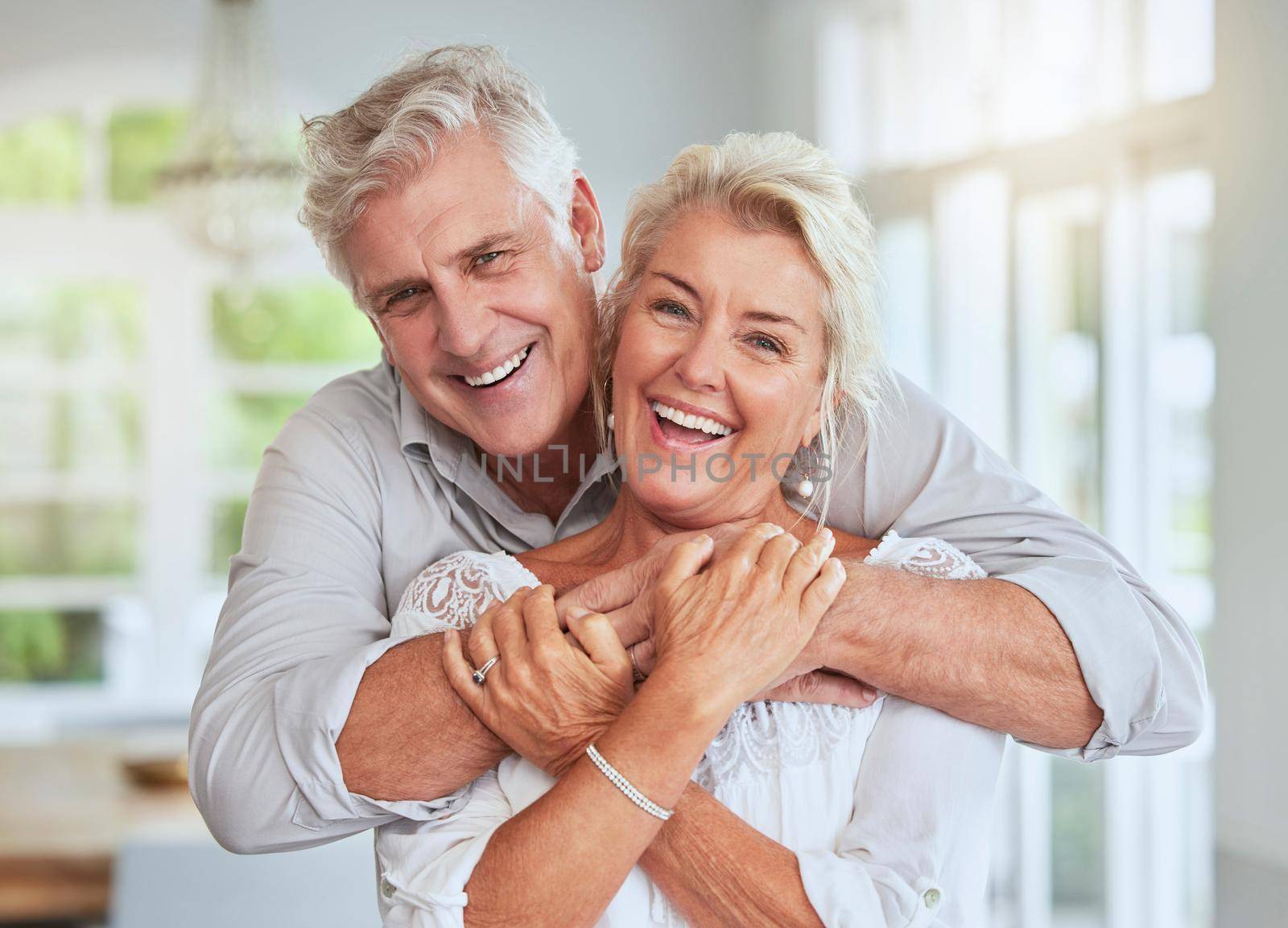Love, couple and retirement with a senior man and woman looking happy and hugging in their home together. Smile, romance and relationship with an elderly male and female pensioner in a house.