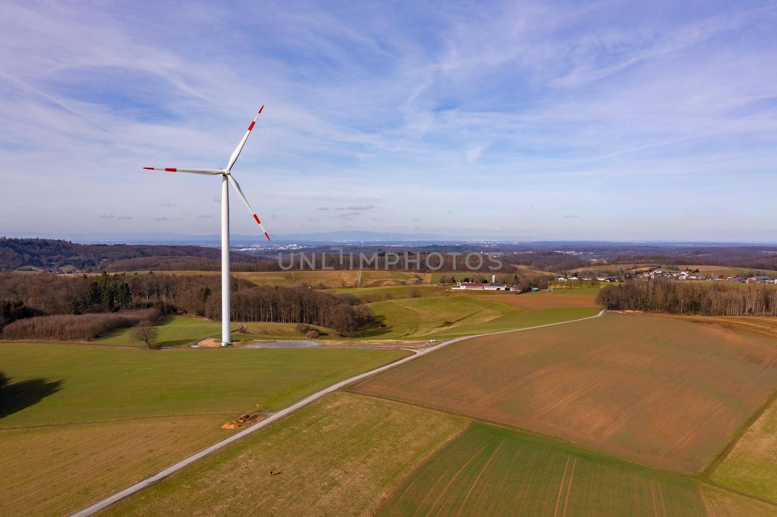 Aerial view of a wind turbine in a rural field in sunshine