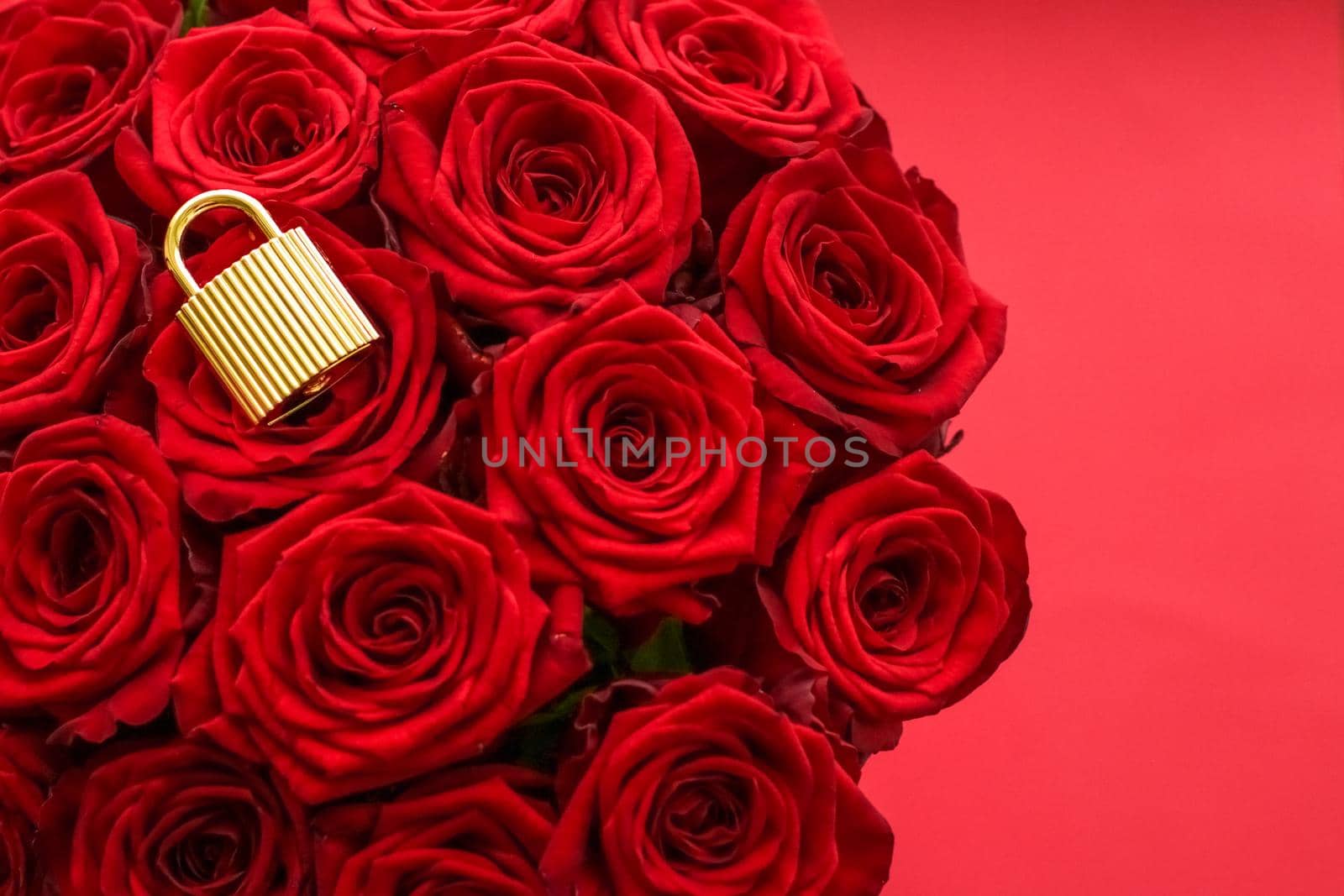 Holiday gift, flowers flatlay and happy relationship concept - Love lock for Valentines Day card, golden padlock and luxury bouquet of roses on red background