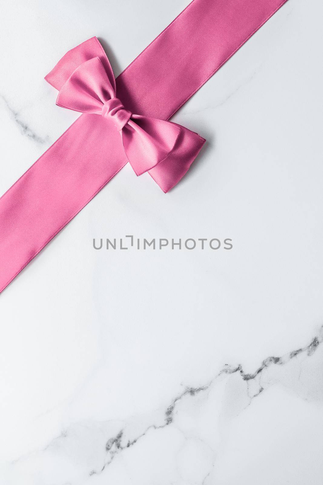 Birthday, wedding and girly branding concept - Pink silk ribbon and bow on marble background, girl baby shower present and glamour fashion gift decor for luxury beauty brand, holiday flatlay design