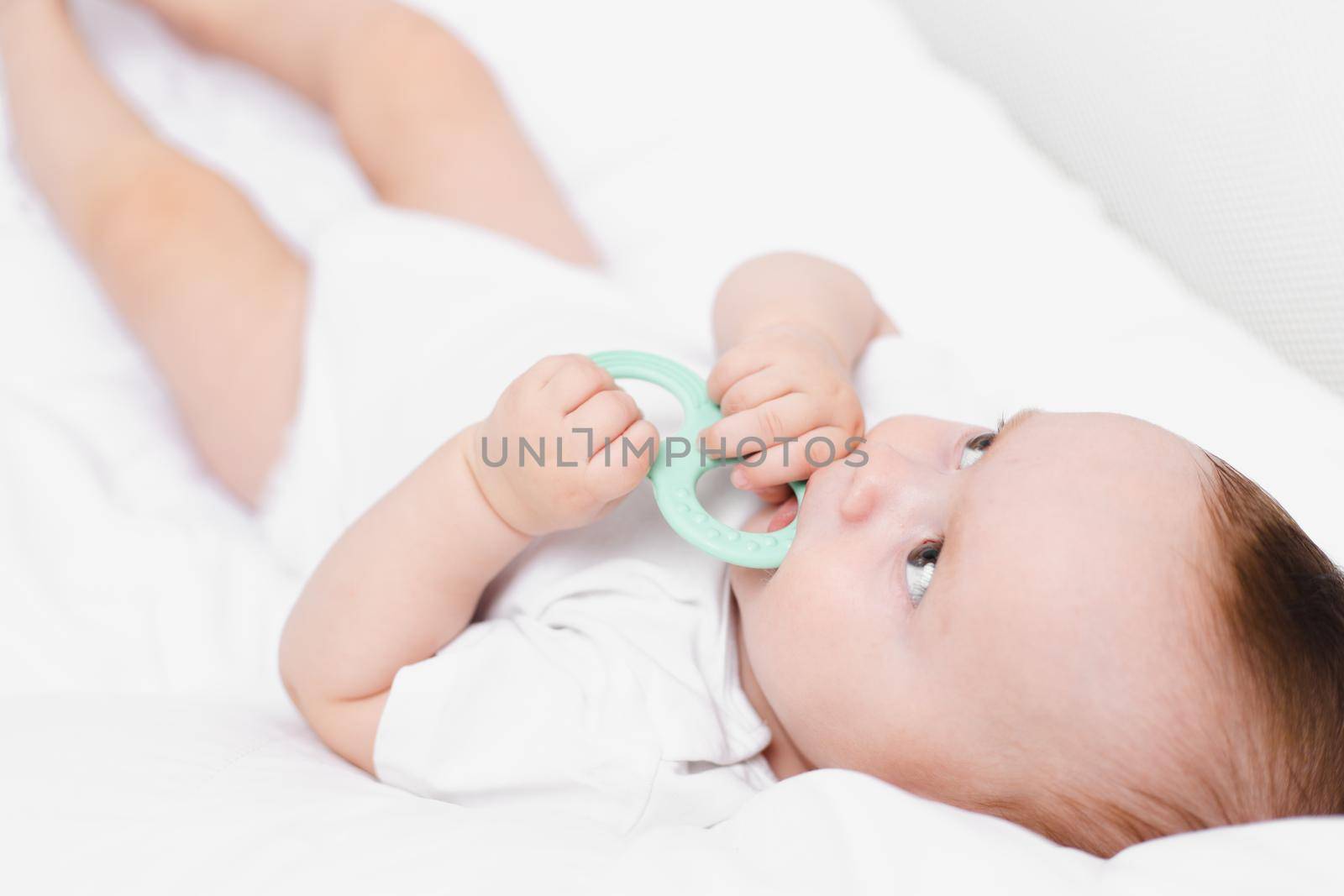 A baby with a teether on a white background . Teething. Children's article. by alenka2194
