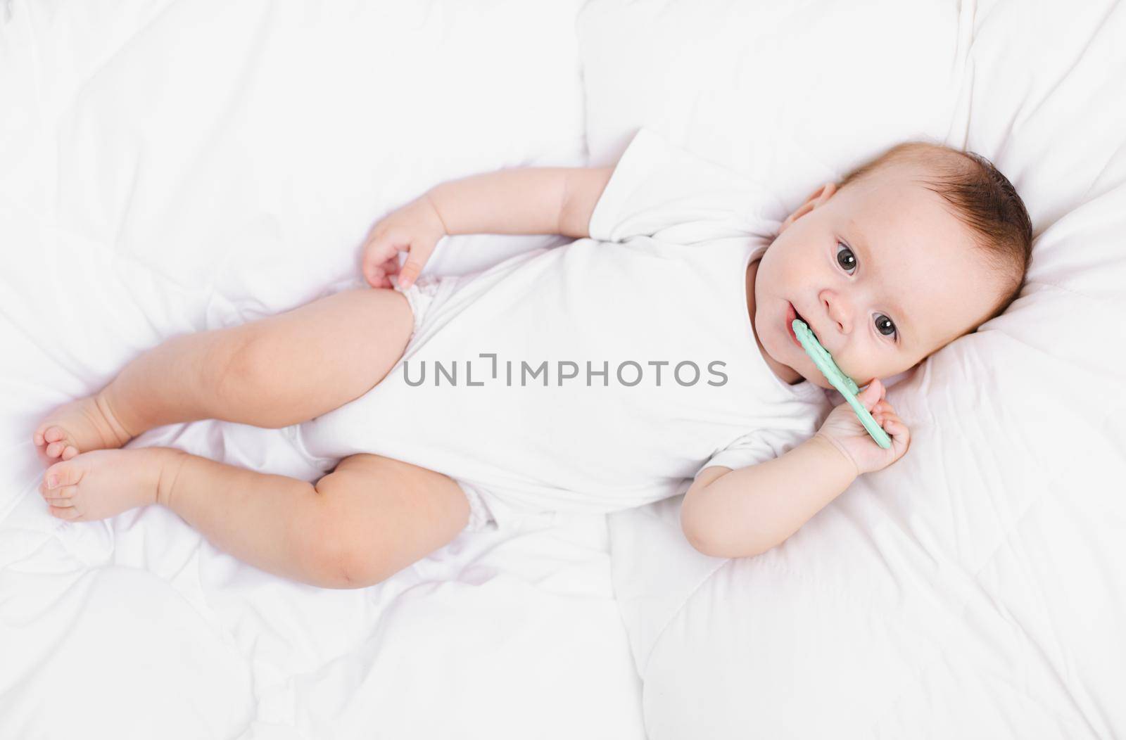 A baby with a teether on a white background . Teething. Children's article. Copy space