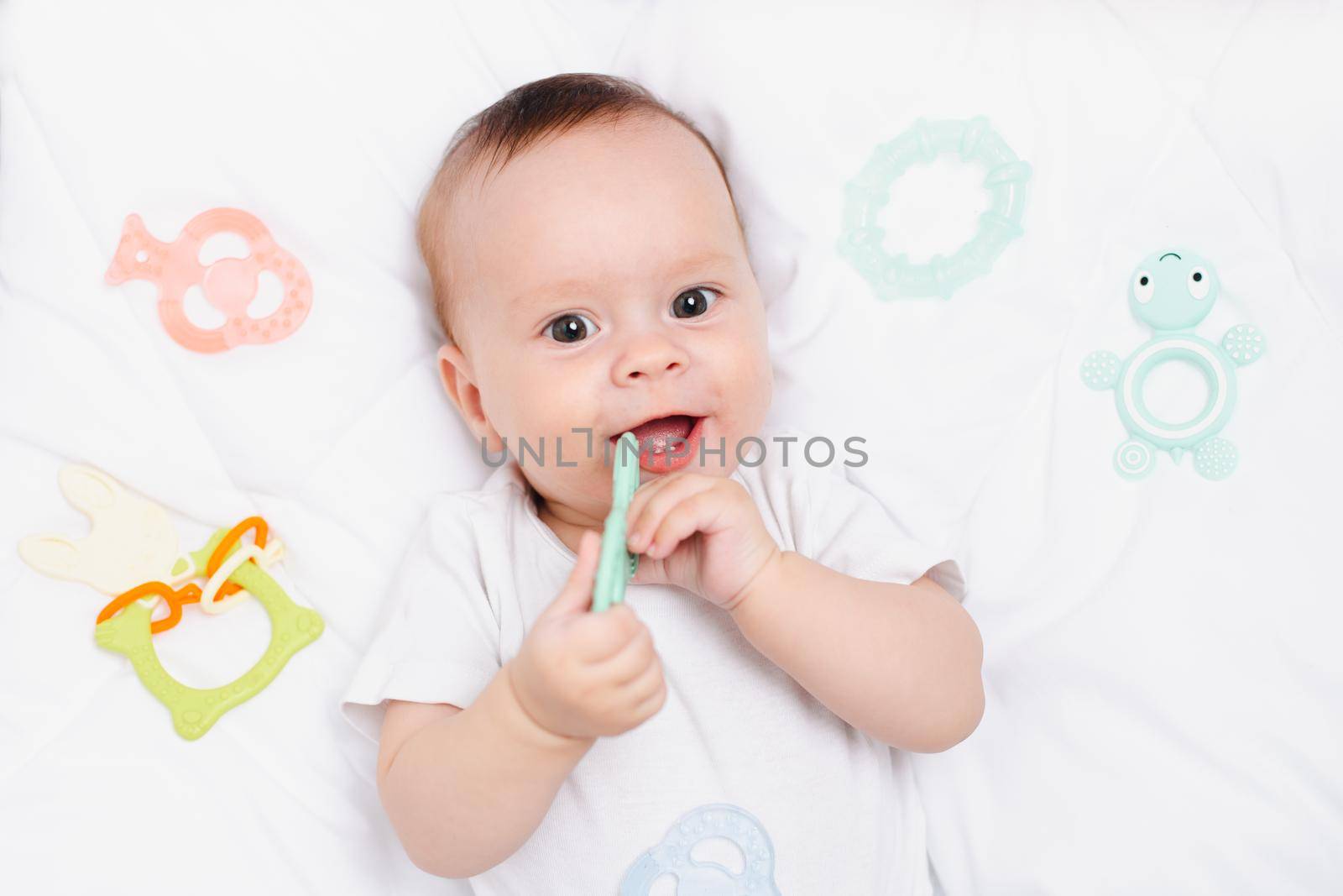 A baby with a teether on a white background . Teething. Children's article. Copy space