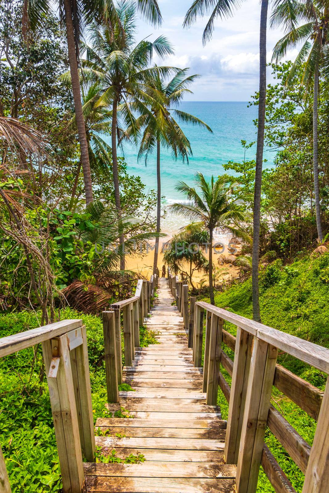 Wood stairs steps down to Naithon Beach turquoise water Thailand. by Arkadij