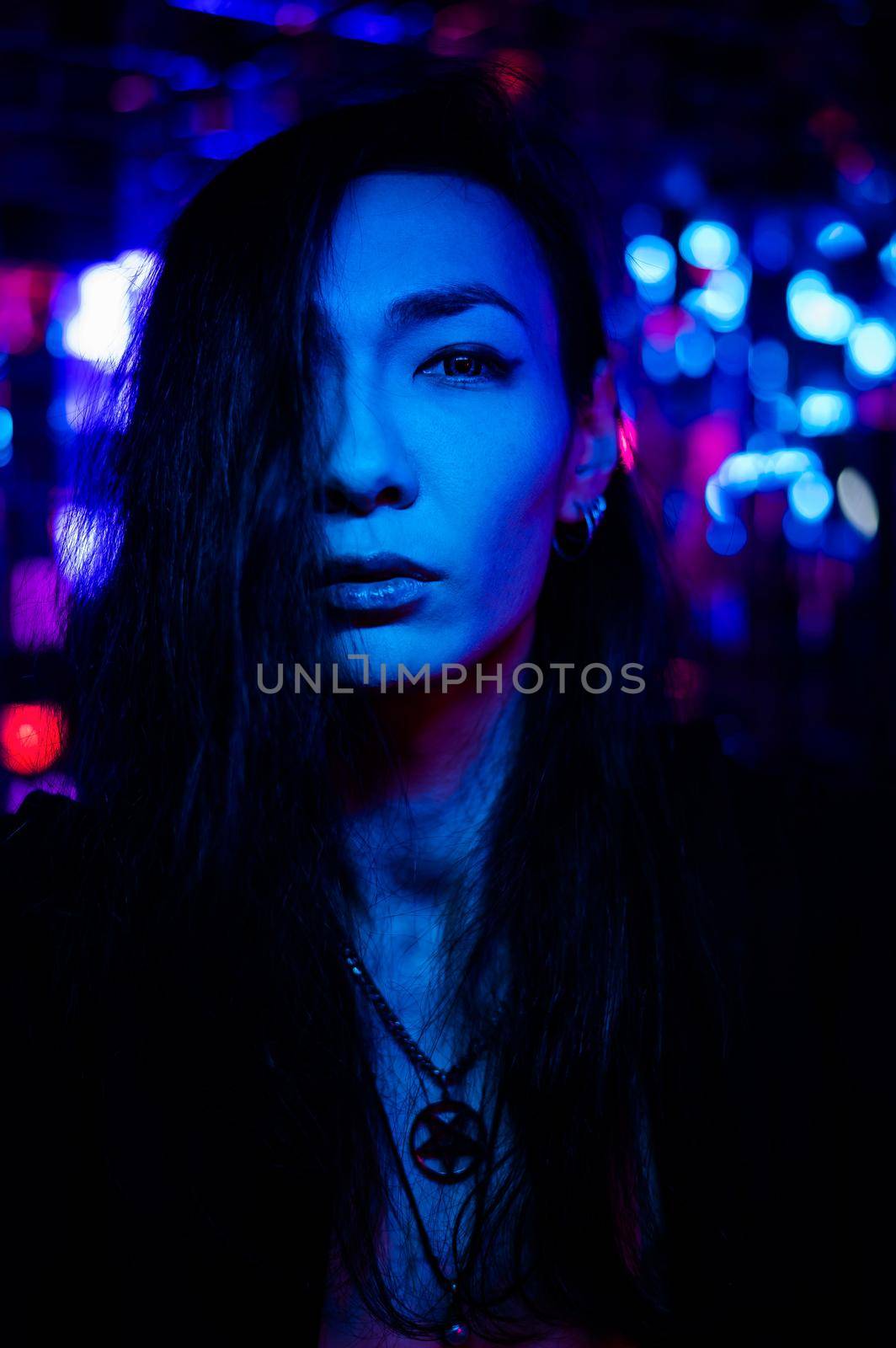 Portrait of a transgender model in a studio with neon lighting