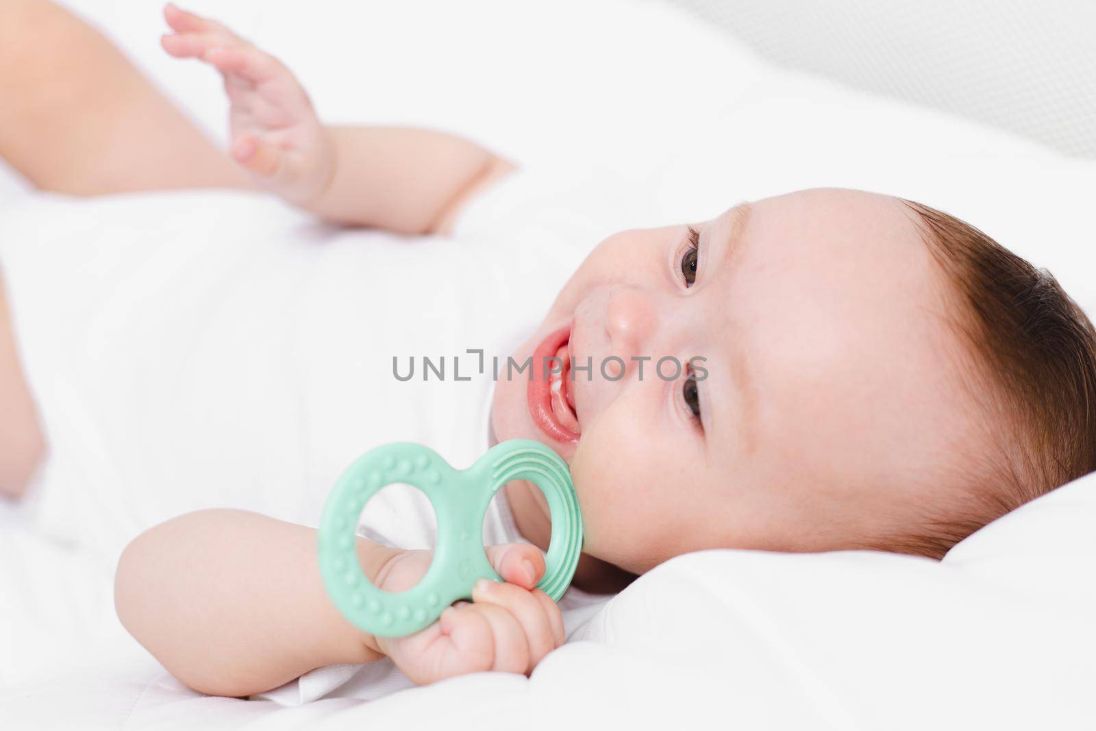 A baby with a teether on a white background . Teething. Children's article. Copy space