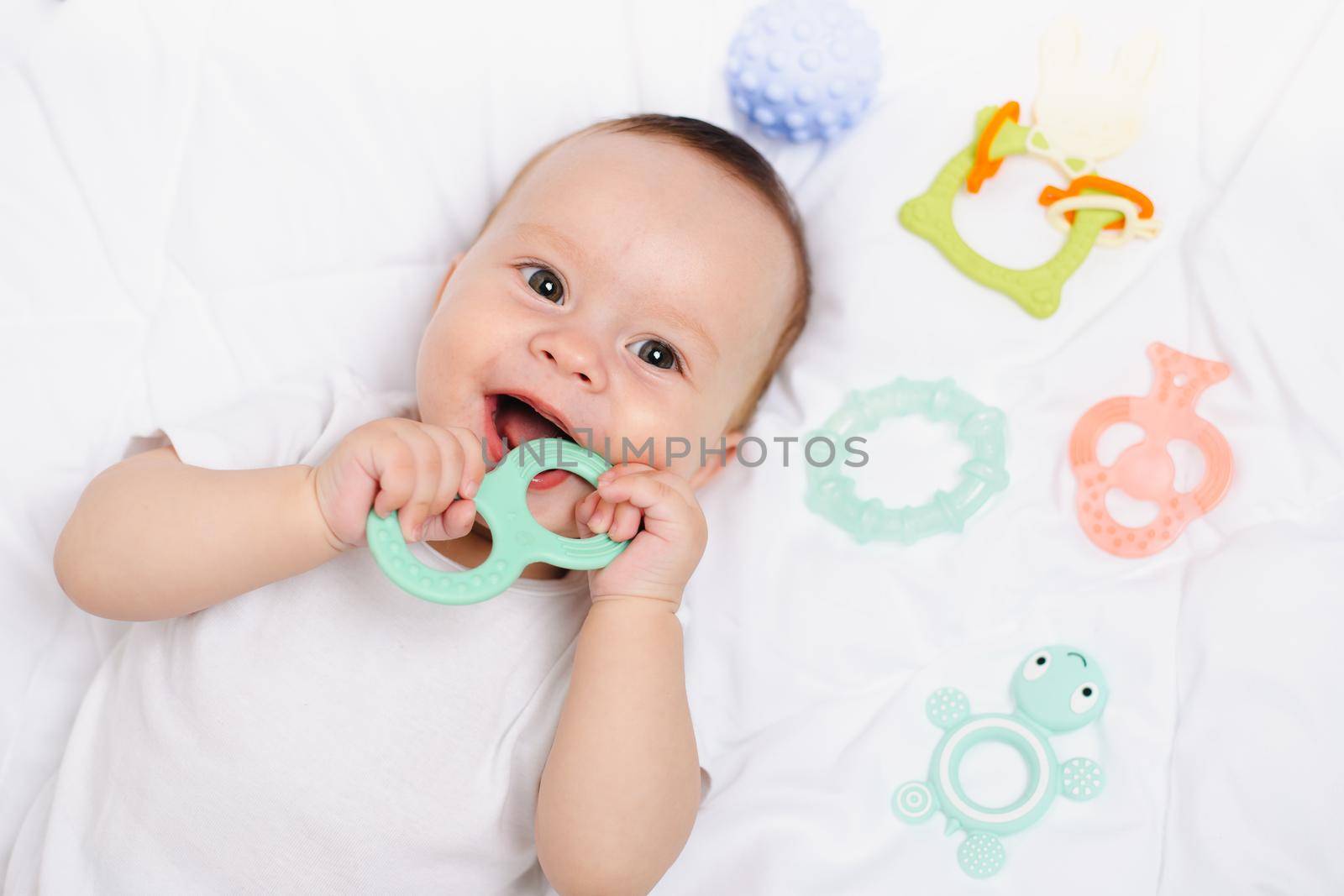 A baby with a teether on a white background . Teething. Children's article. Copy space