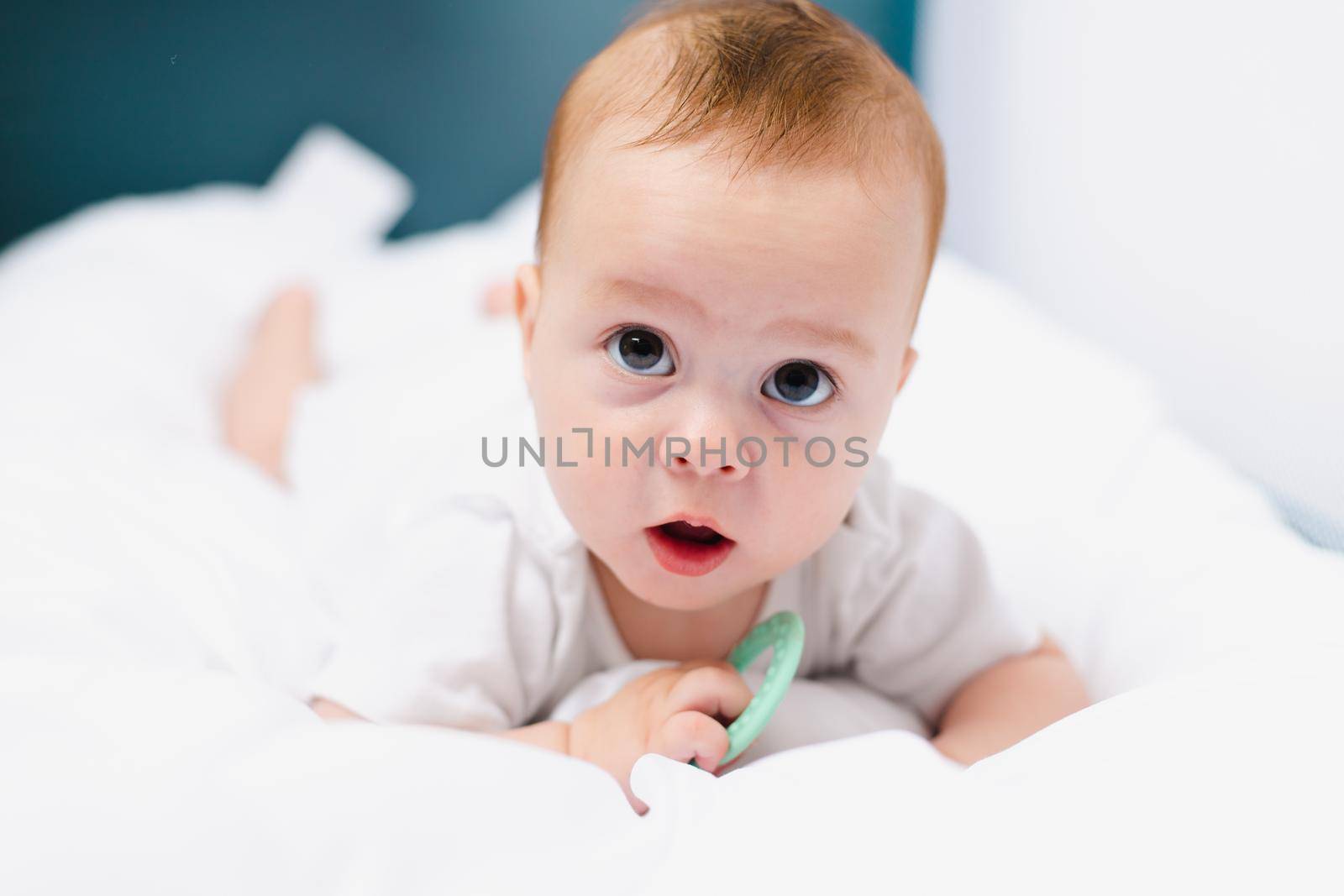 A baby with a teether on a white background . Teething. Children's article. Copy space