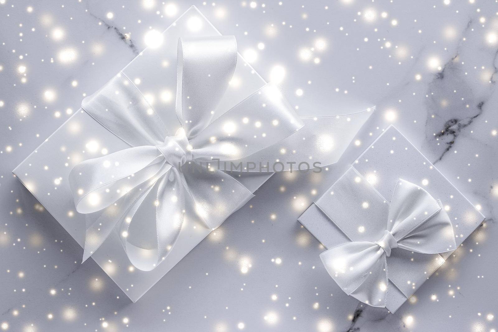 New Years Eve celebration, winter decoration and Valentines Day presents concept - Luxury holiday gifts with white silk bow and ribbons on marble background, Christmas time surprise