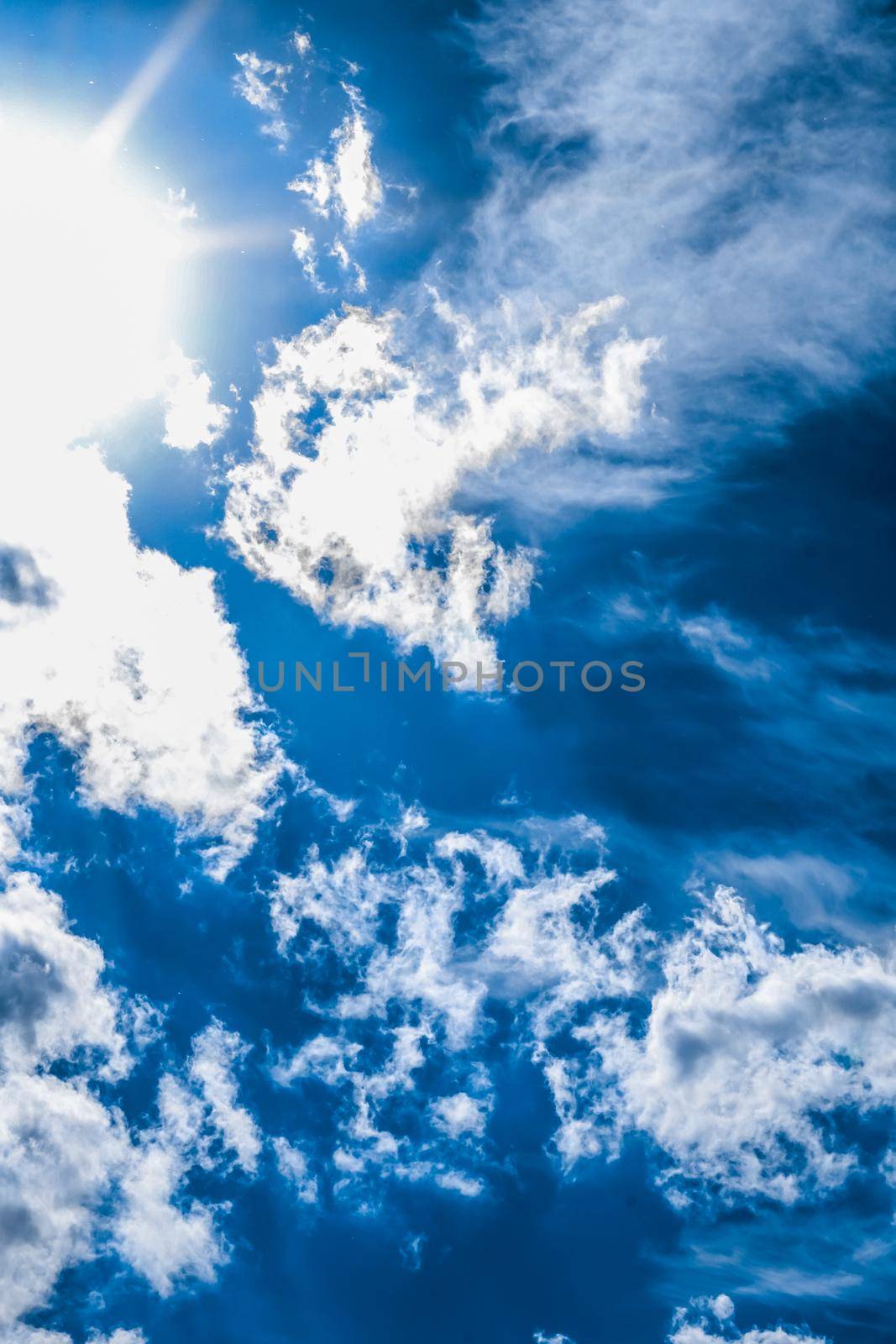 Nature backdrop, solar energy and spiritual concept - Blue sky background, white clouds and bright sunlight