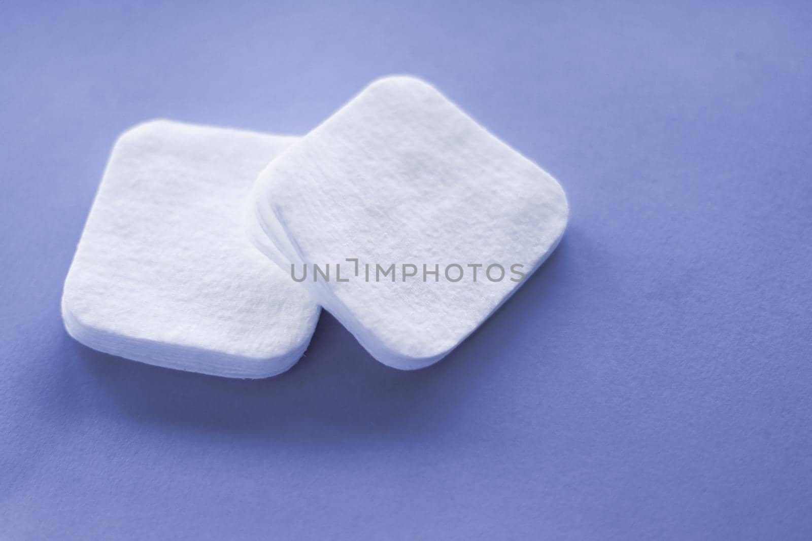 Cosmetology, cleanliness and branding concept - Organic cotton pads on purple background, cosmetics and make-up remover, hygiene and skincare beauty brand product for healthcare and medical design