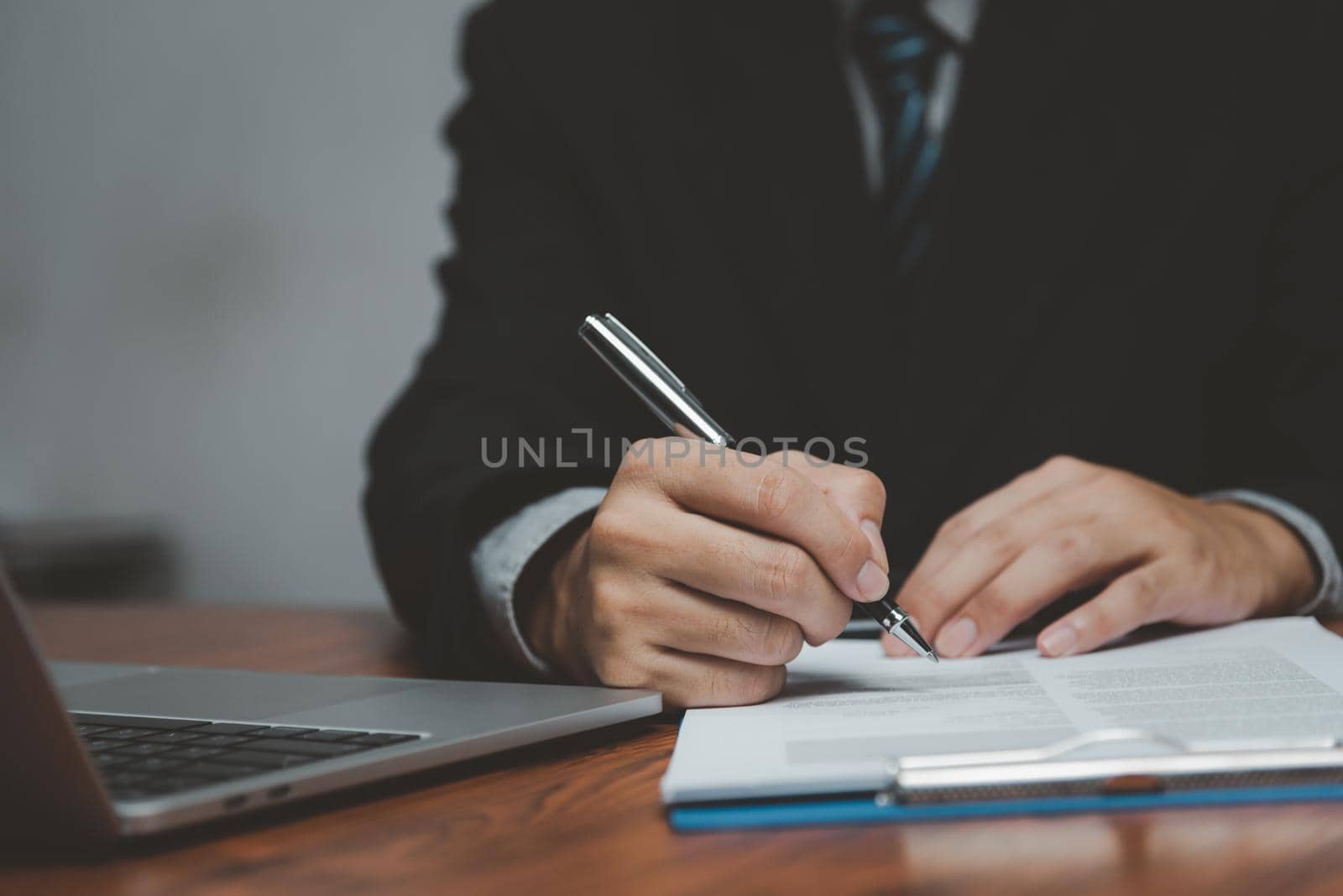 businessman holding pen signature document on clipboard at desk. Business information insurance lawyer and job concept.