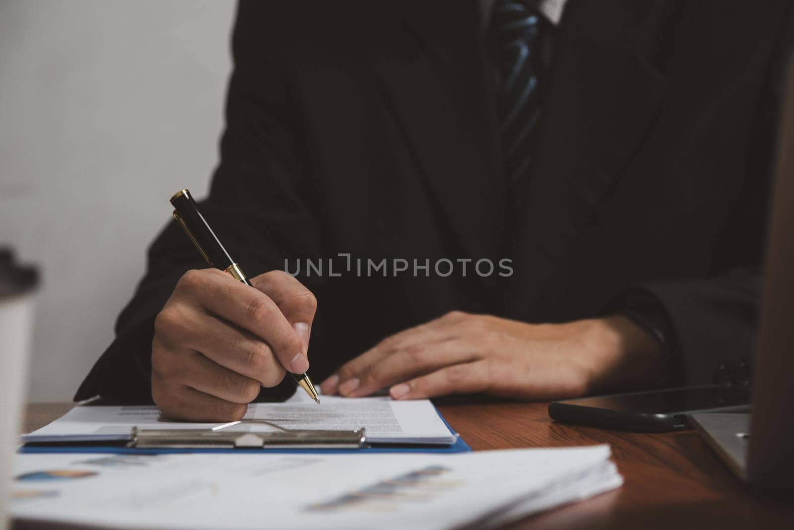 businessman holding pen signature document on clipboard at desk. Business information insurance lawyer and job concept.