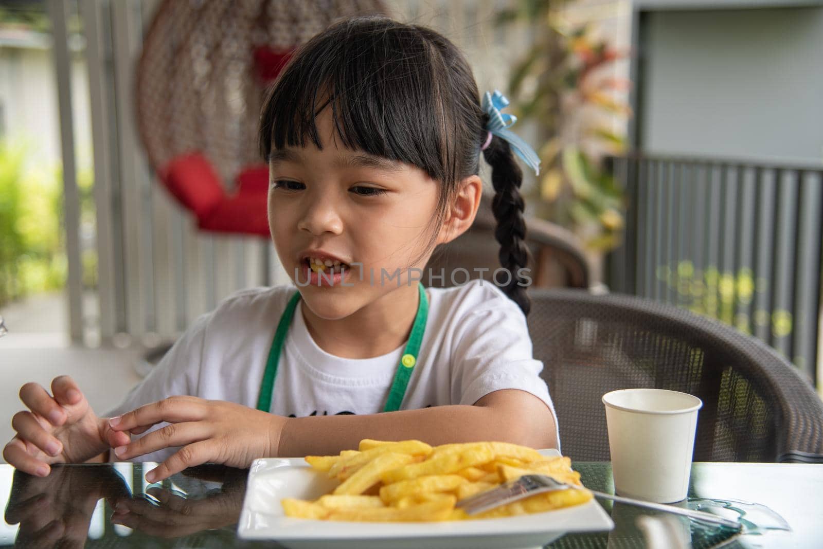Young Asian girl eating french fries young kid fun happy potato fast food. by aoo3771