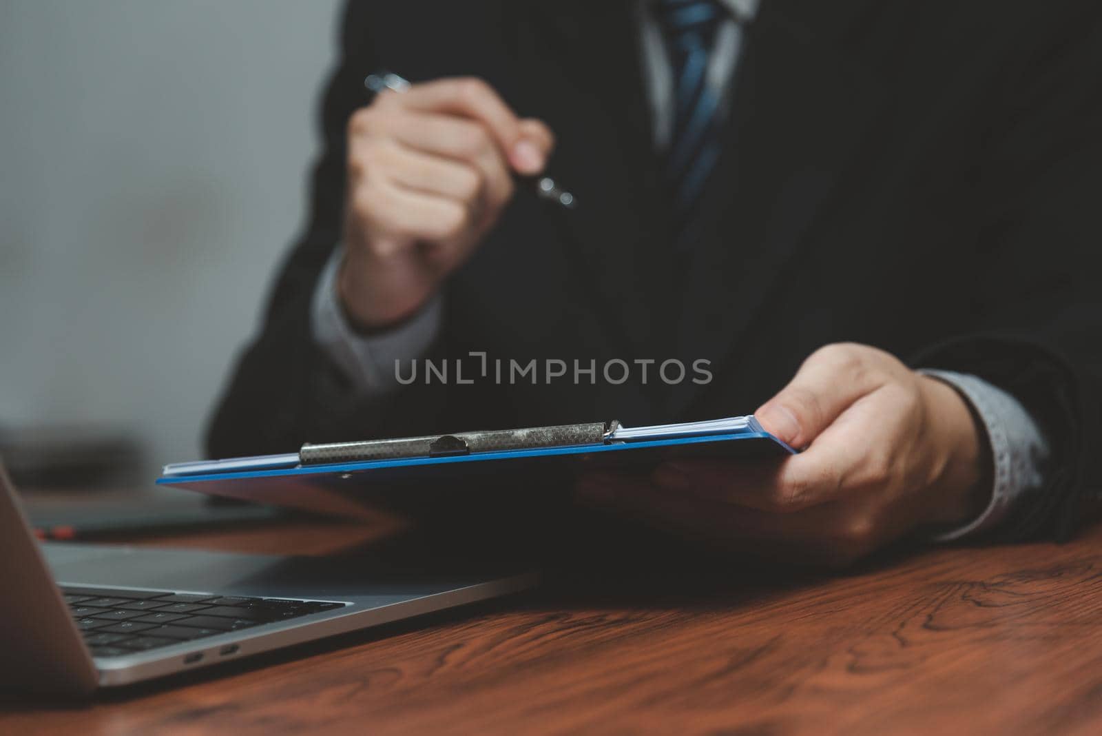 businessman holding pen signature document on clipboard at desk. Business information insurance lawyer and job concept.