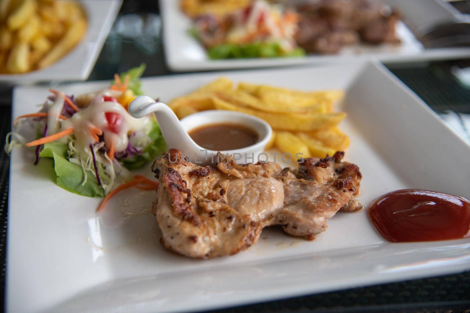 Steak chicken and salad vegetable in dish on table.