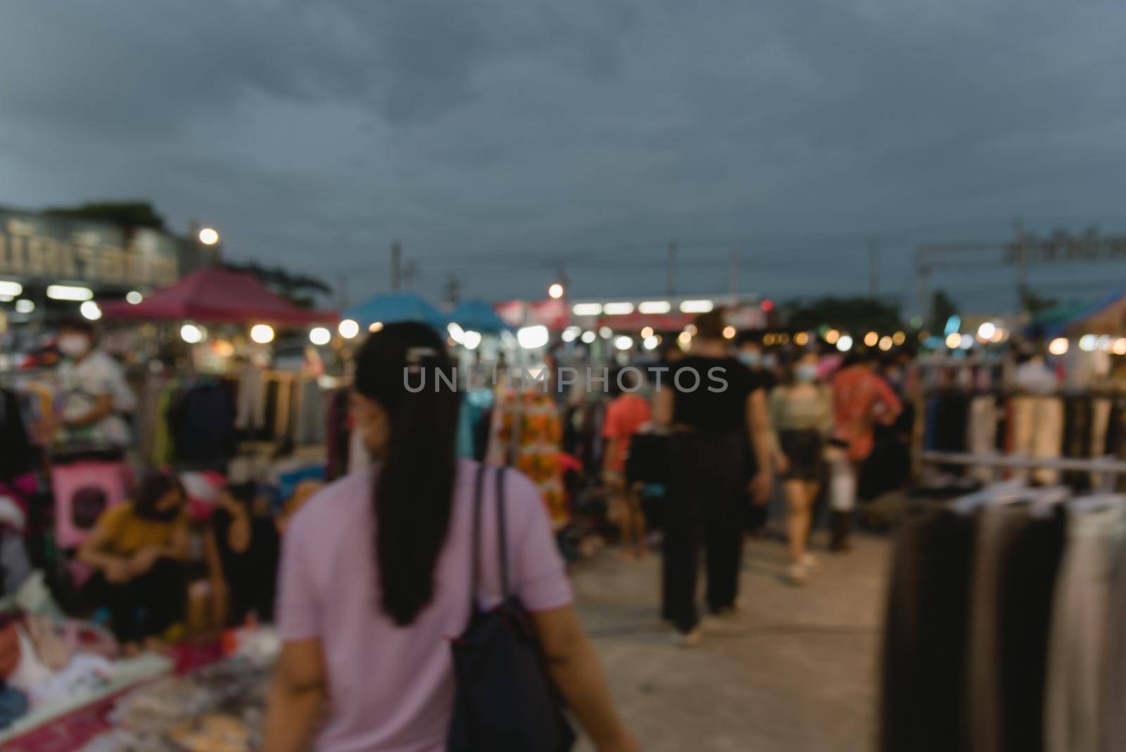 blurred image of night market festival people walking on road with light bokeh for background.