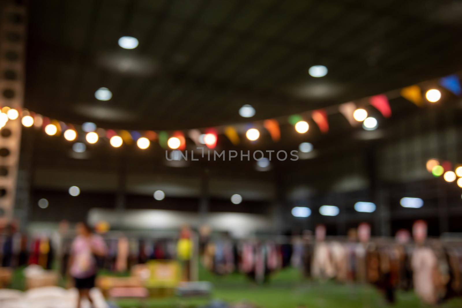 blurred image of night market festival people walking on road with light bokeh for background.
