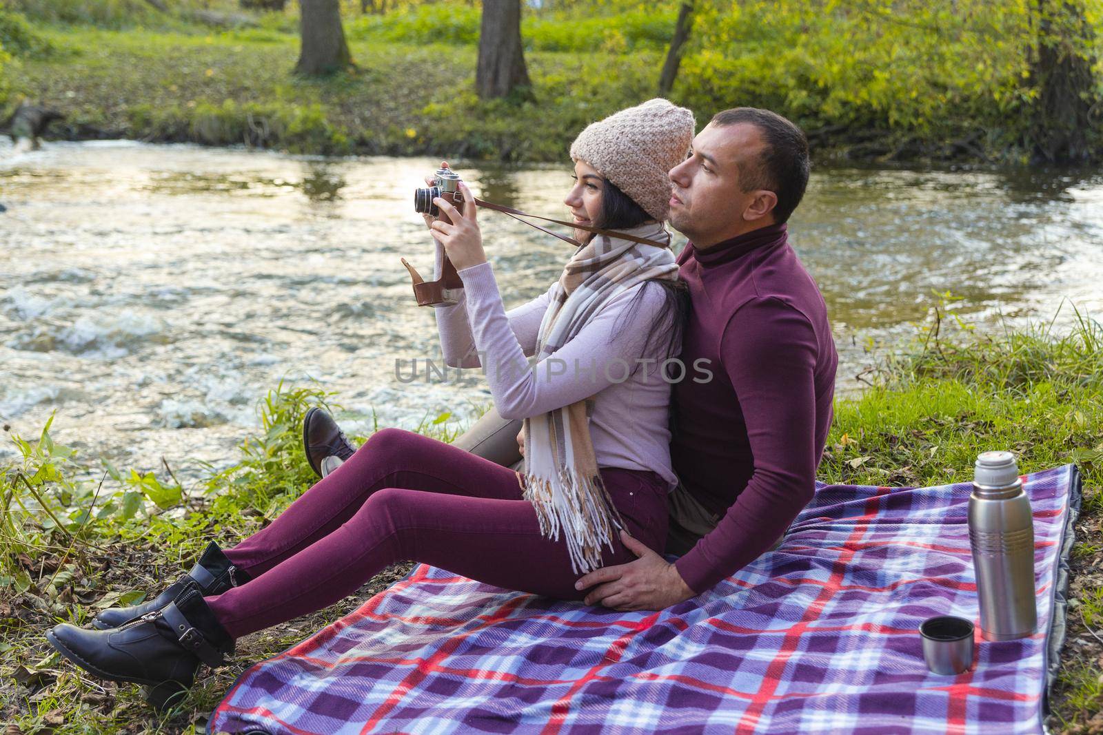 A happy couple on a picnic by the river by BY-_-BY