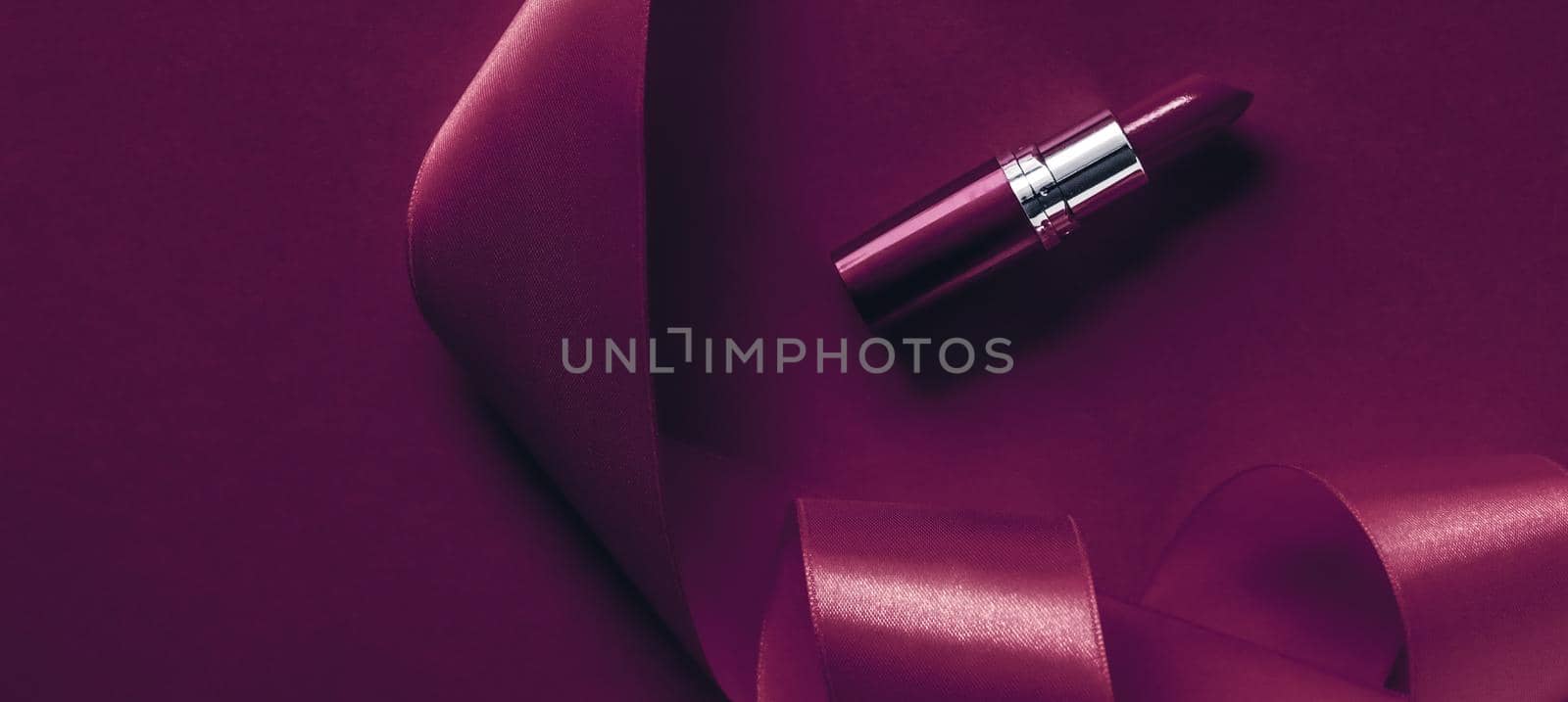 Luxury lipstick and silk ribbon on plum holiday background, make-up and cosmetics flatlay for beauty brand product design by Anneleven
