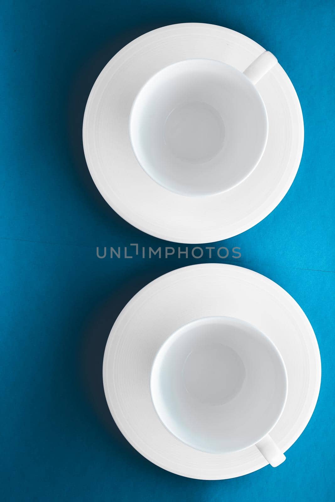 White tableware crockery set, empty cup on blue flatlay background by Anneleven