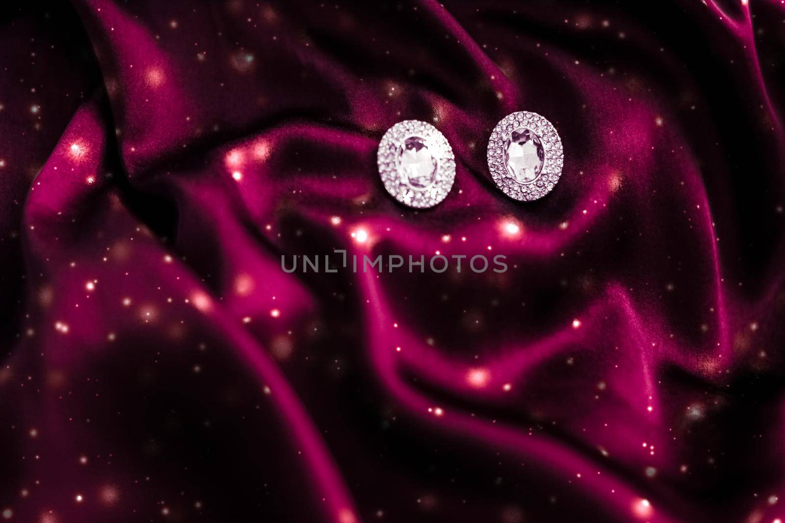 Jewellery brand, Christmas shopping and New Years gift concept - Luxury diamond earrings on dark red silk with snow glitter, holiday winter magic jewelery present
