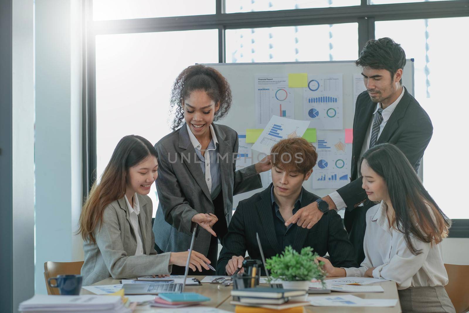 Asian business woman leader workers a paper business plan in a group meeting. Emphasis on female mentor teachers Train a variety of employees in corporate office workshops. by wichayada