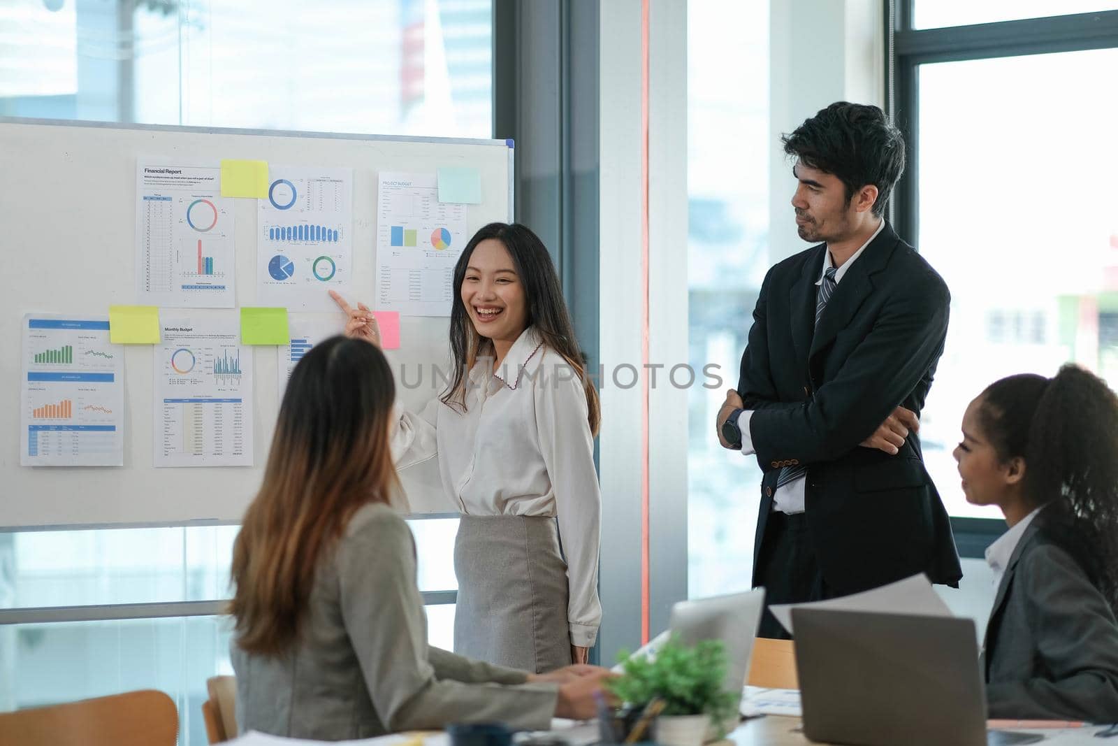 Female Operations Manager Holds Meeting Presentation for a Team of Economists. Asian Woman Uses Digital Whiteboard with Growth Analysis, Charts, Statistics and Data. People Work in Business Office..