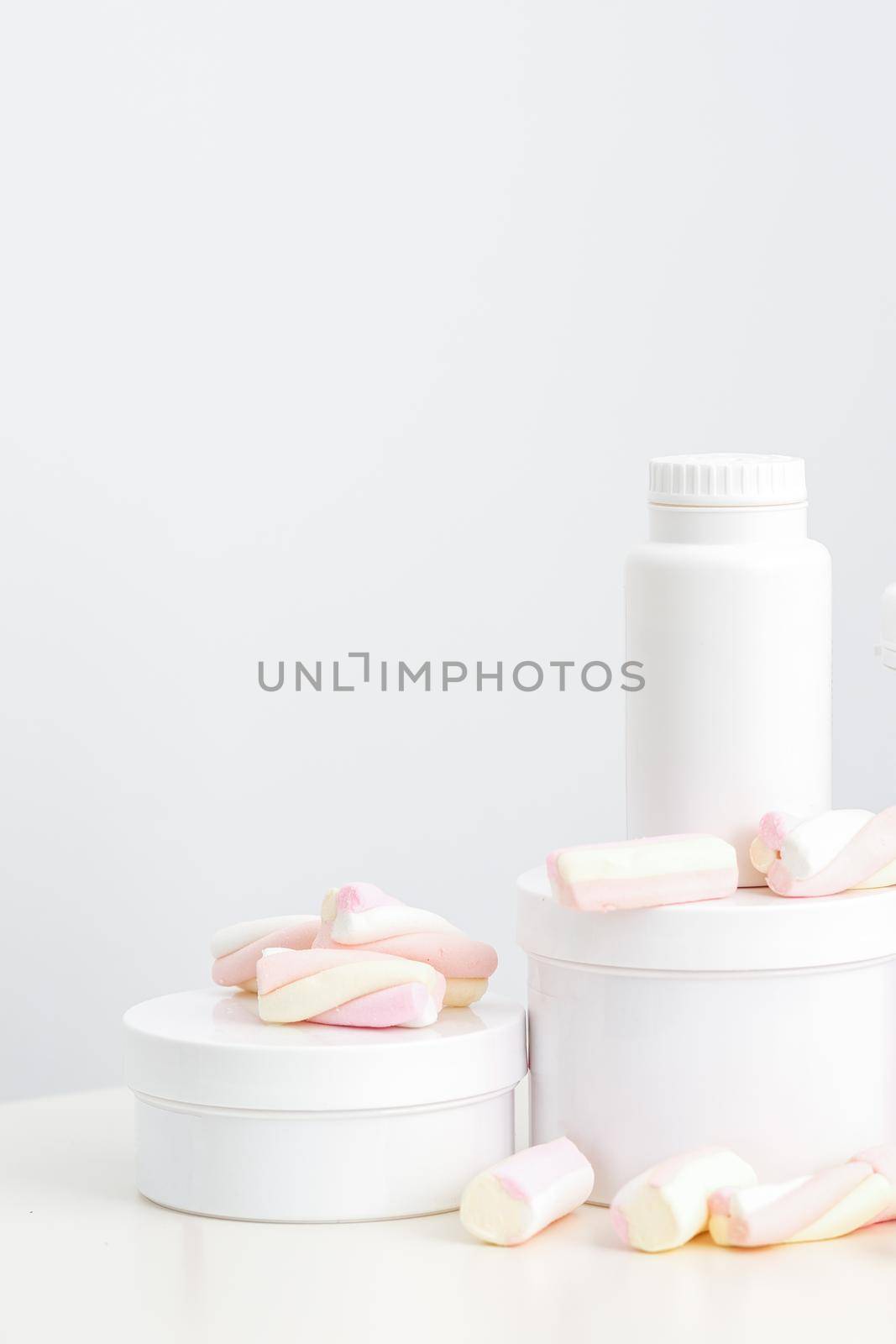 Cosmetic skincare packaging. Beauty product on white background. White jars with marshmallows on the white table