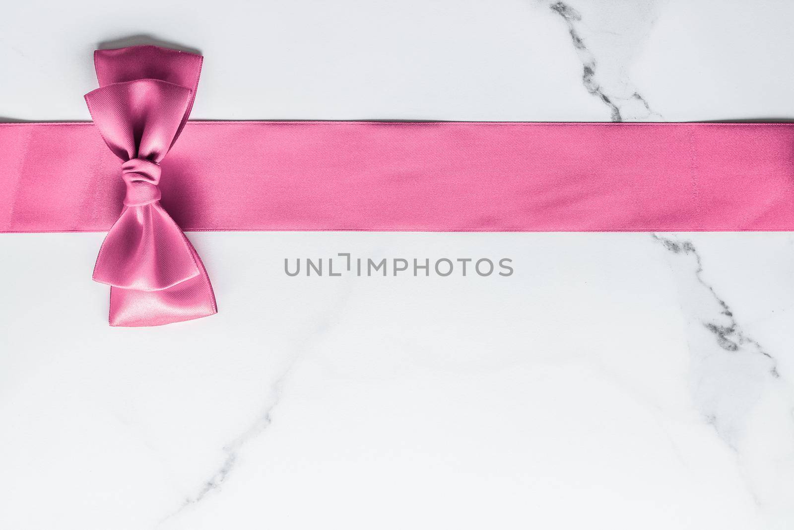 Birthday, wedding and girly branding concept - Pink silk ribbon and bow on marble background, girl baby shower present and glamour fashion gift decor for luxury beauty brand, holiday flatlay design