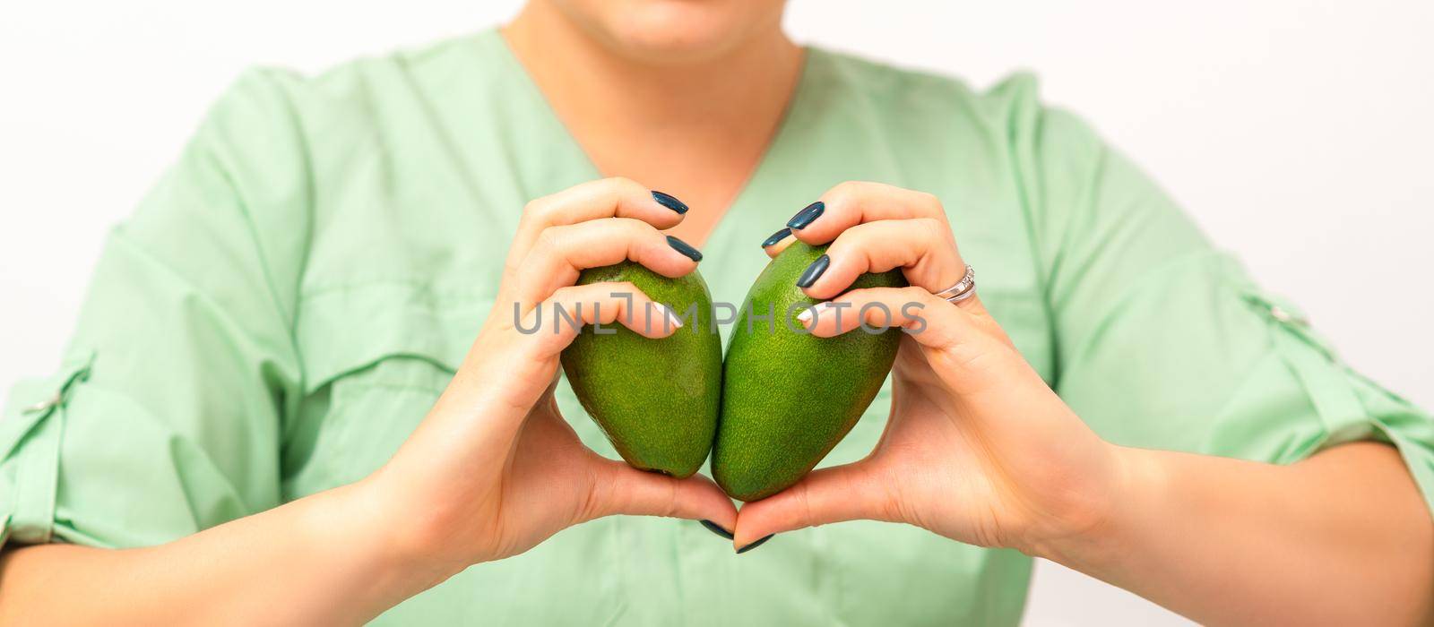 Female nutritionist doctor holding organic avocado fruit. Healthy lifestyle concept