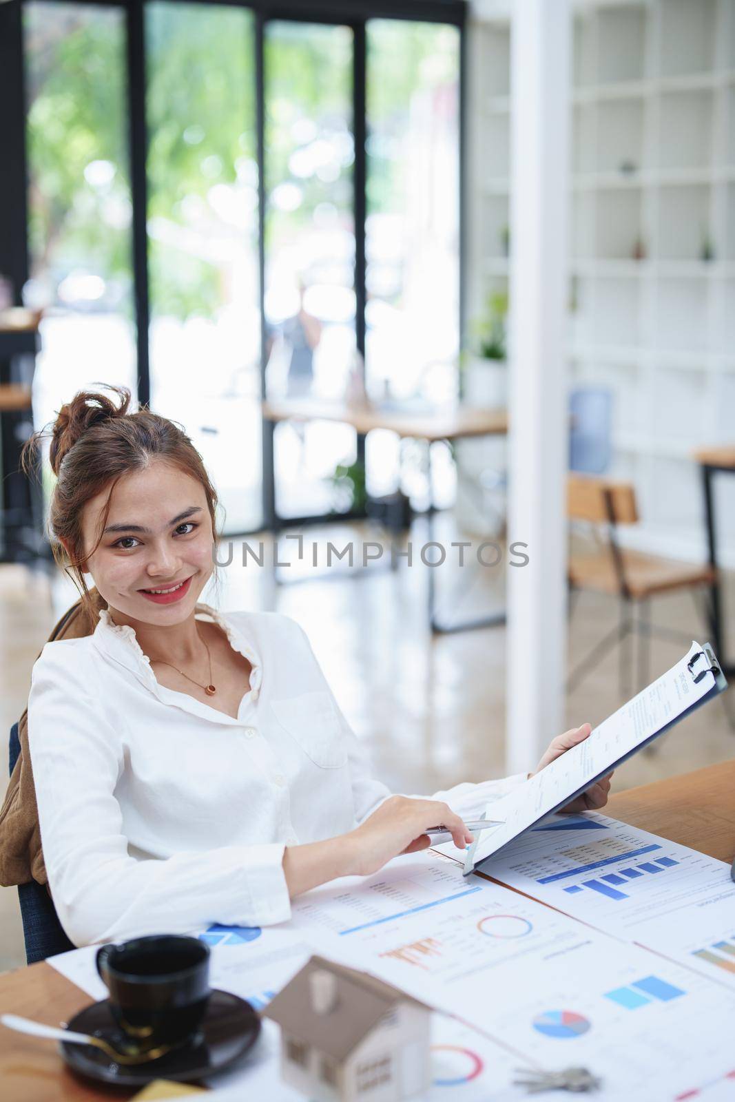 Portrait of a beautiful bank young woman sign credit department of signing approval for a home loan.