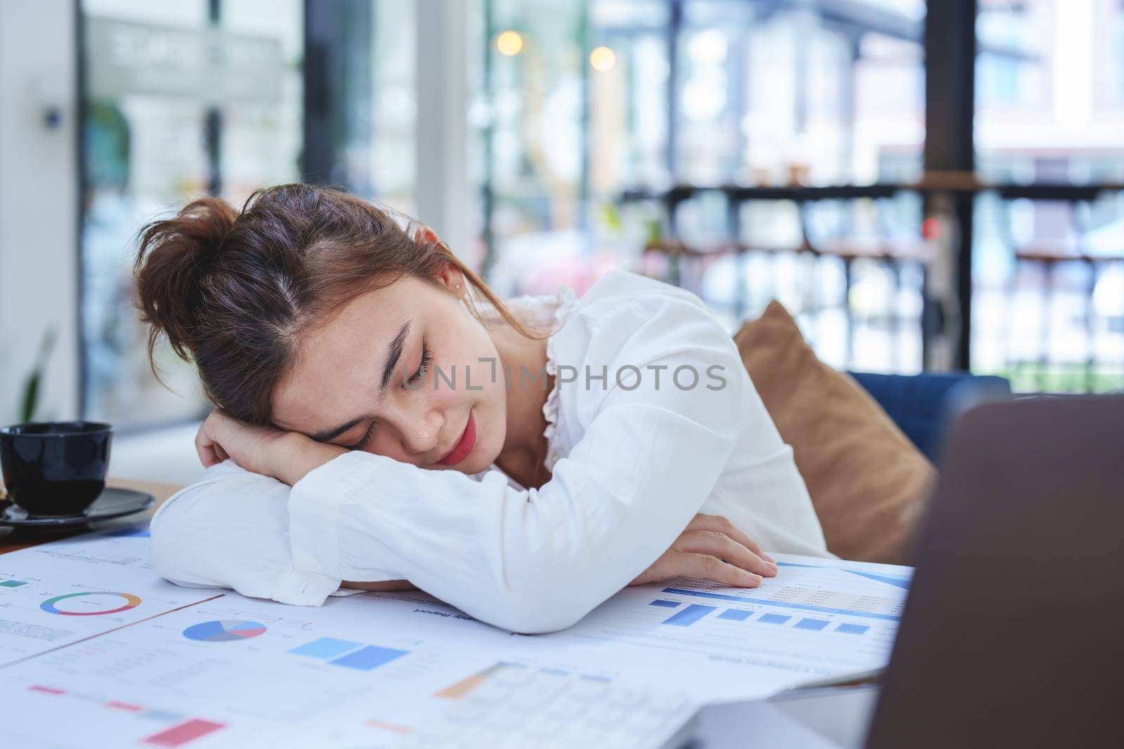 Portrait of a woman employee showing fatigue working on paperwork.