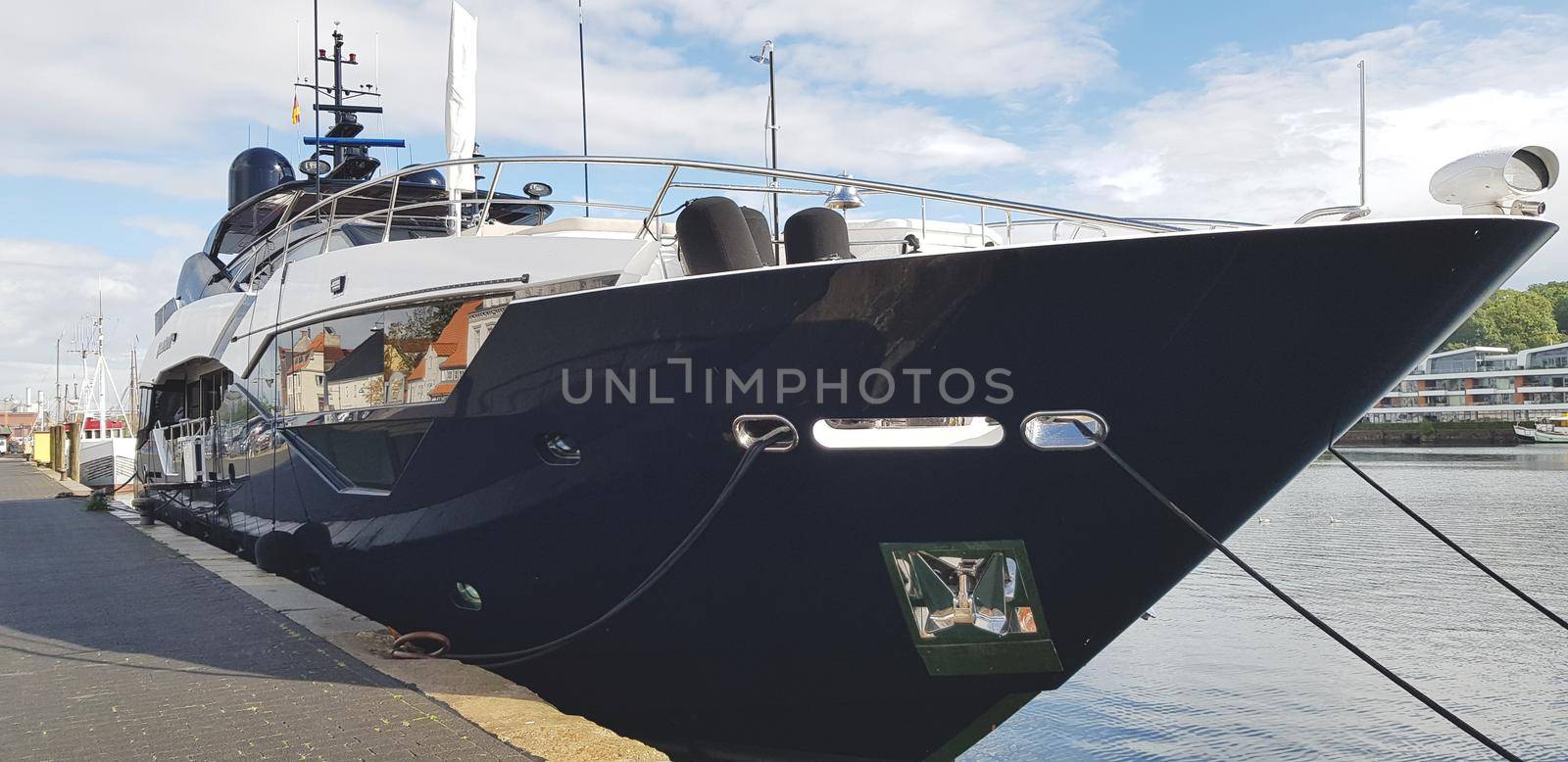 Luxury big black yacht in the port by banate