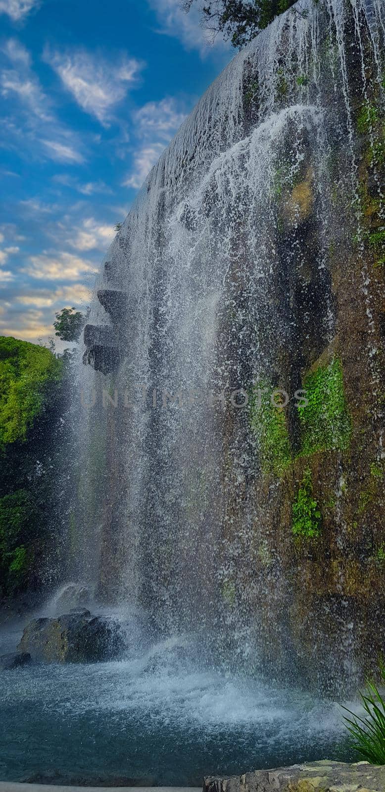 close up of small waterfall on the hill with blue sky. High quality photo